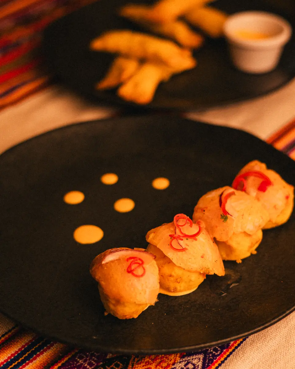 Piqueos de ceviche sobre bolinhos, em prato de pedra